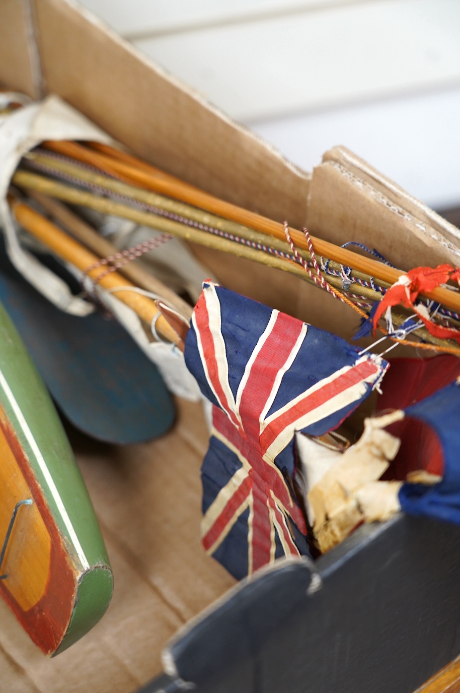 Two Tri-ang pond yachts, one painted tin plate, the other painted wood, together with various masts and flags. Condition - poor to fair